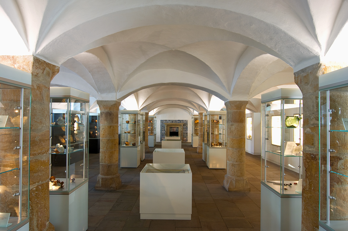 Innenansicht des Falkenhofs mit Blick auf Ausstellungsstücke in den Vitrinen.